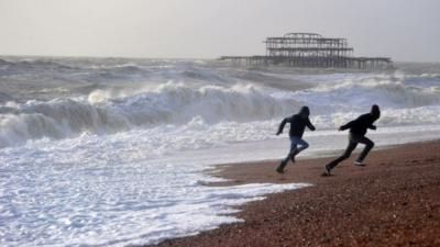 Youths run back from waves