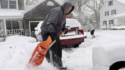 Man and woman digging out driveway