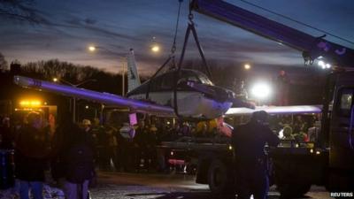 Plane being lifted onto flat bed truck