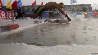 Swimmers dive into ice covered Songhua River, Harbin