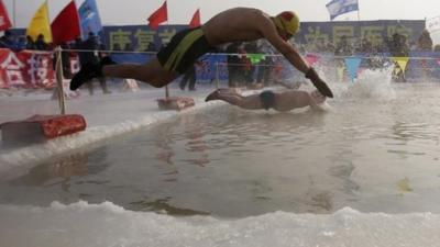 Swimmers dive into ice covered Songhua River, Harbin