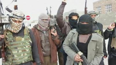 al-Qaeda linked militants hold weapons