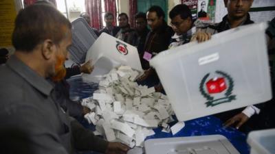 Bangladeshi election officials open a ballot box to count votes