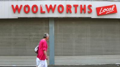 Woman walks past Woolworths shop front