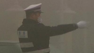 Beijing traffic officer in smog