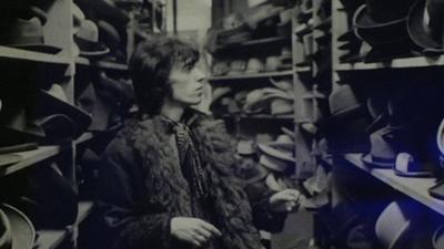Bill Wyman, former guitarist for the Rolling Stones in a hat shop