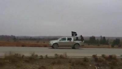 A still from video footage shows the black flag of the ISIS rebel group