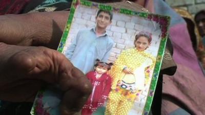 Pakistani mother holding photograph of children