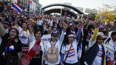 Anti-government protesters block the road at one of major intersections in central Bangkok