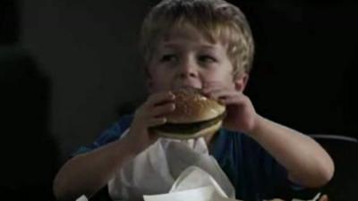 Young boy eats burger