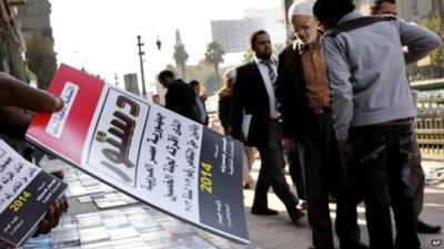 Egyptian vender sells copies of the new constitution in Cairo