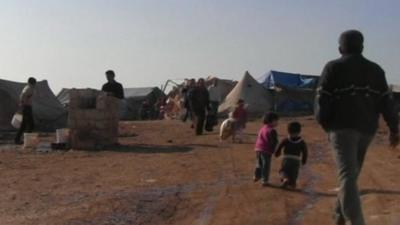 Man and children in Syrian refugee camp