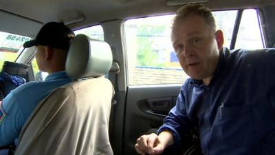 The BBC's Angus Crawford travels with a police escort in a car in Ibabao in the Philippines