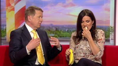 Bill Turnball looks on at Susanna Reid eating a banana