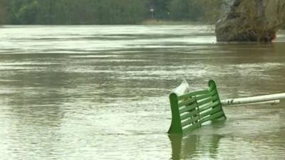 Park bench submerged under floodwater