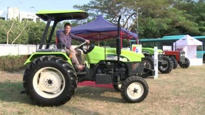 Jonah Fisher sits on a tractor at Yangon trade fair