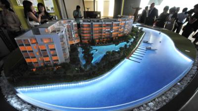 People looking at a model of a condominium