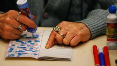 An elderly woman playing bingo