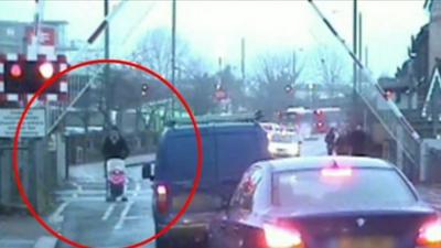 Man pushing pushchair jumps level crossing