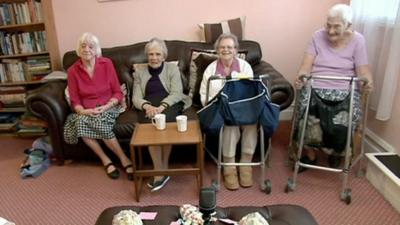 Residents of care home sit on sofa