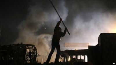 A protester stands on top of a barricade during during clashes with police in central Kiev, Ukraine