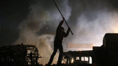 A protester stands on top of a barricade during during clashes with police in central Kiev, Ukraine