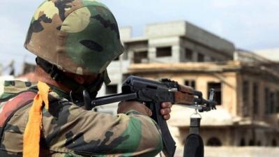 A Syrian army soldier takes his position, at a street in Sabina suburb