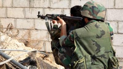 Syrian army soldiers take their positions on a street in Sabina suburb, south of Damascus, Syria in Nov 2013