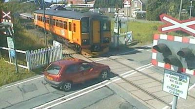 Near miss between car and train on level crossing