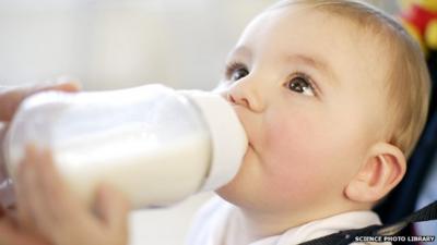 Nine month old boy drinking a bottle of milk