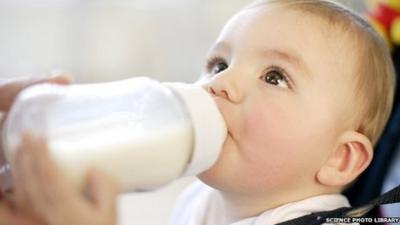 Nine month old boy drinking a bottle of milk