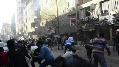 Men in street ducking as explosion rocks Cairo