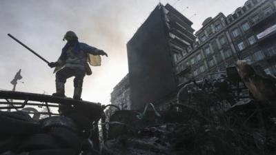 An anti-government protester stands on a barricade