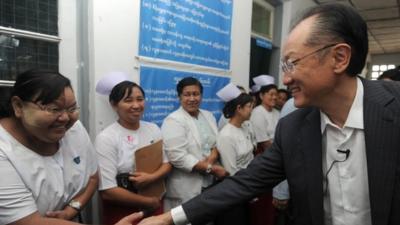 Jim Yong Kim, president of the World Bank Group, shakse hands with a nurse as he arrives at a township hospital on the outskirts of Yangon