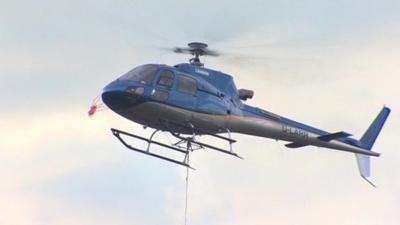 Helicopter carries large bag of fine slate