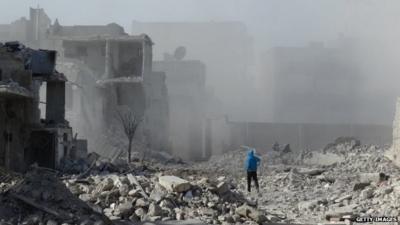 Man stands amid rubble in Aleppo