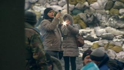 Man and woman take photo on their phones