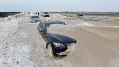 Vehicles are stuck in the snow on the road near the city of Backa Topola, northern Serbia