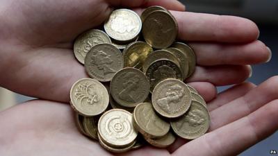 A person holds pound coins