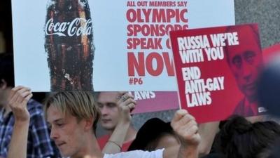 Pro-gay activists hold placards calling for Sochi Winter Olympic sponsors to speak out against Russia's anti-gay laws during a protest in Melbourne on Wednesday