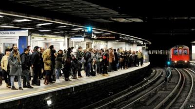 Passengers wait on the east bound platform of the District Line at Victoria Station