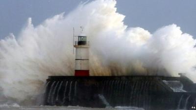 Wave crashing over harbour wall in Sussex