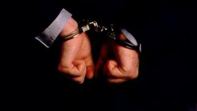 An anonymous man in handcuffs