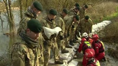 Emergency teams put out sandbags