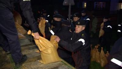 Footage shows the army and navy working together to try and build a sand bag barrier along the Thames