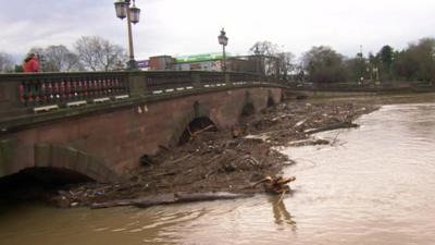 Debris and silt gathered around bridge supports in Worcester