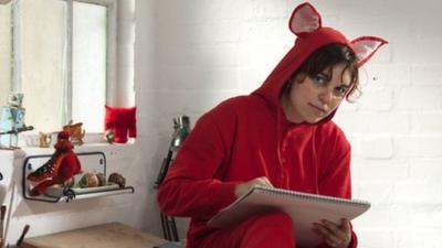 Woman dressed in red animal onesie