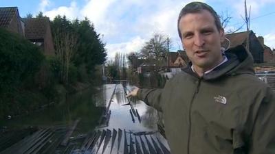 Richard Westcott pointing out submerged electric rails outside Datchet station