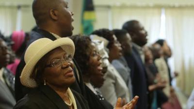 People singing during Redeemed Church service in Massachusetts