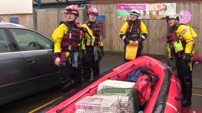 RSPCA rescue team with boat full of cages and equipment